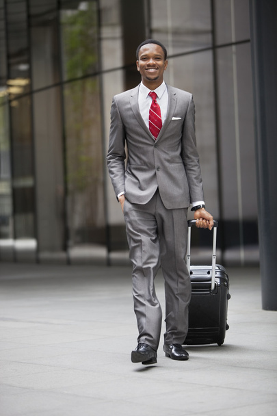 businessman walking with wheeled suitcase - 写真・画像
