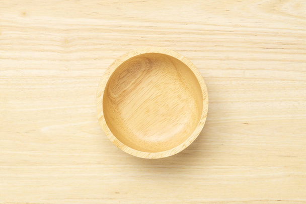 Top view of empty clean wooden bowl on wooden texture background - Fotó, kép
