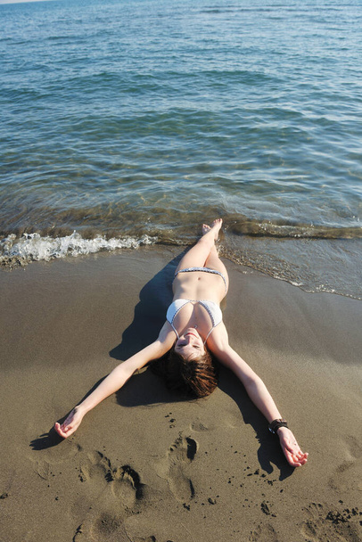 šťastná mladá žena relaxovat na krásné pláži v čerstvém letním ránu a vychutnat si první paprsek slunce - Fotografie, Obrázek