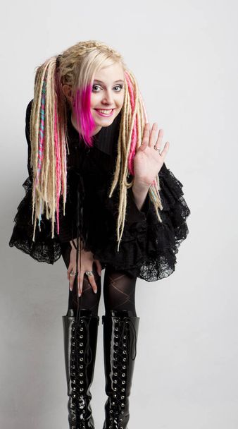 young woman with dreadlocks wearing extravagant clothes and boots - 写真・画像