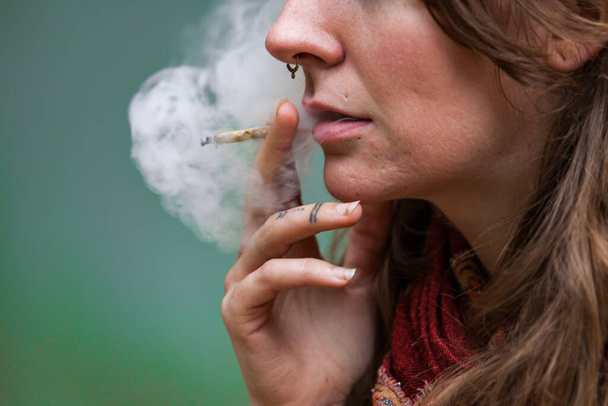 Коноплі курила біла жінка на відкритому повітрі
 - Фото, зображення