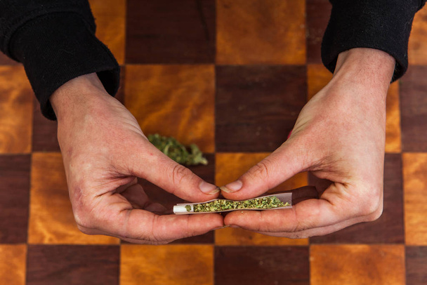 Hand rollt Cannabis-Joint von Grund auf - Foto, Bild