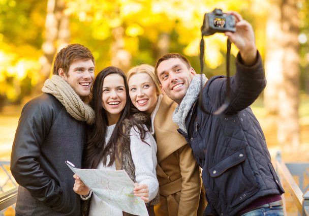 Group of friends with photo camera in autumn park - Foto, Bild