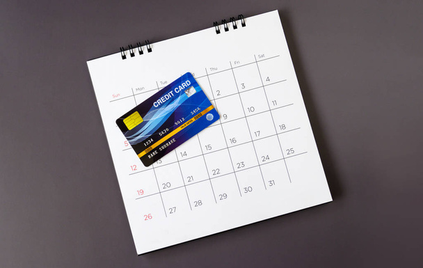 Kalender met dagen en creditcard op tafel. winkelconcept - Foto, afbeelding