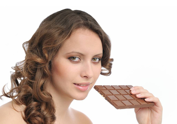 Young beautiful sensual woman holding bar of chocolate isolated on white background - Fotó, kép