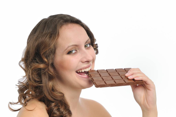 Young beautiful smiling woman eating milk chocolate isolated on white background - Photo, image