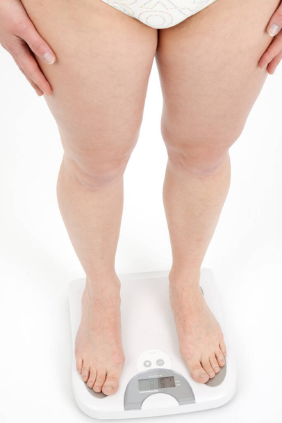 young woman weighs on a bathroom scale - Zdjęcie, obraz