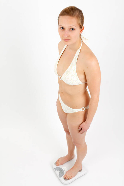 young woman weighs in on a bathroom scale - Фото, зображення