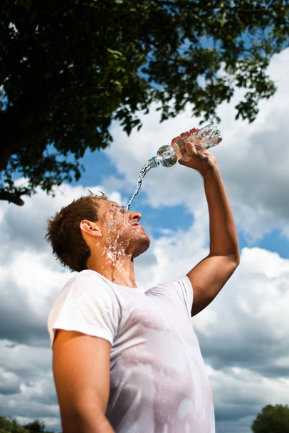 sportsman refreshing himself with a bottle of water - Foto, Imagen