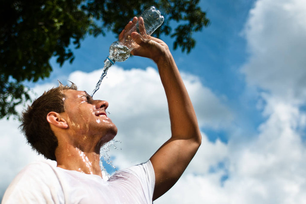 sportsman throwing water over his head for refreshment - Foto, Imagen