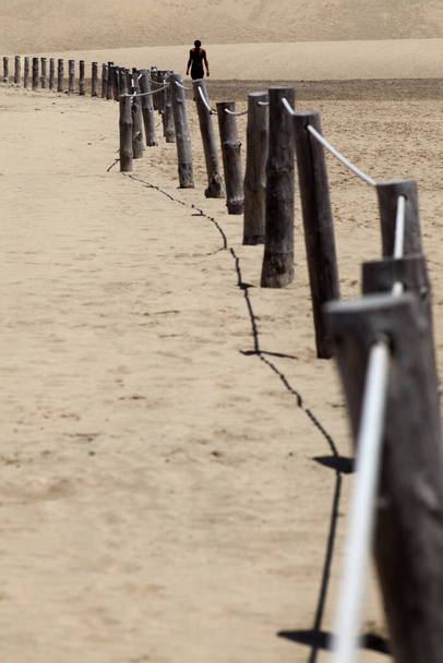 walking along the fence in the desert - Photo, Image