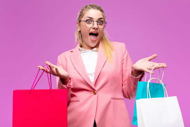 young pretty blonde woman holding shopping bags - Foto, afbeelding