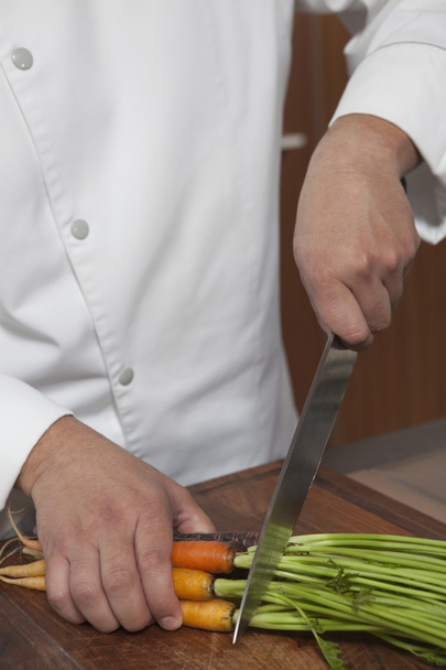 chef cutting carrots at kitchen  - Photo, Image