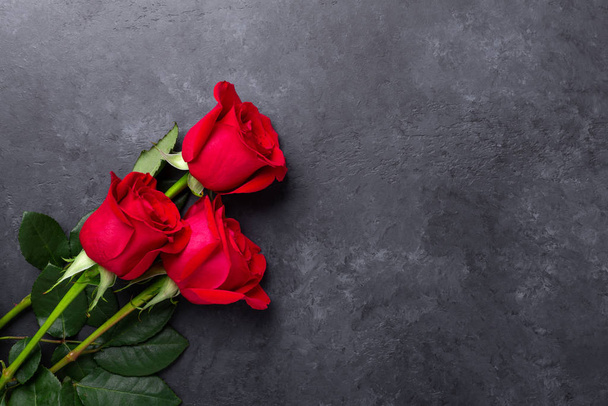 Red rose flowers bouquet on black stone background Valentines day greeting card - Фото, зображення
