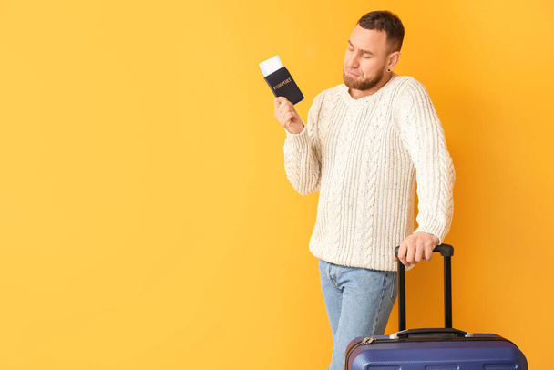männlicher Tourist mit Dokumenten und Gepäck auf farbigem Hintergrund - Foto, Bild