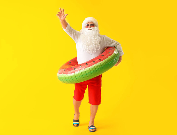 Santa Claus con anillo de natación sobre fondo de color. Concepto de vacaciones
 - Foto, Imagen