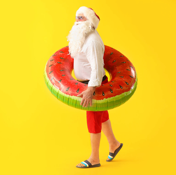 Santa Claus with swimming ring on color background. Concept of vacation - Foto, immagini