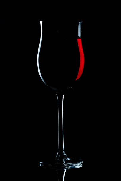 red wine in burgundy glass against a dark background - Fotó, kép
