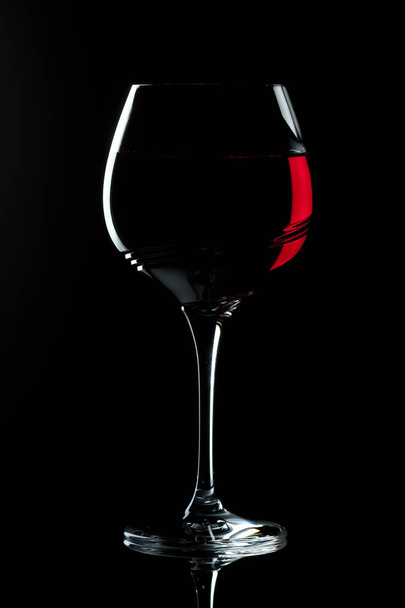 red wine in patterned wineglass against a dark background - Фото, изображение