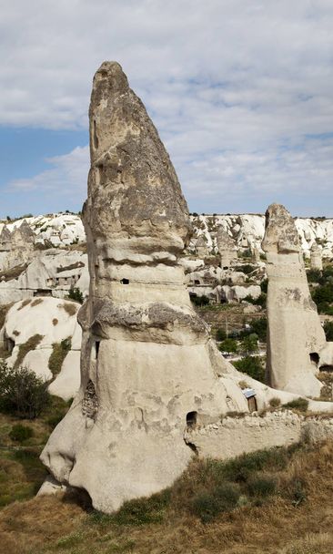 Limestime weathered into fairy chimneys, Goreme, Cappadocia, Kapadokya, Turkey, portrait, copy space, crop area, bule cloudy sky, liemstone cliff - Fotó, kép