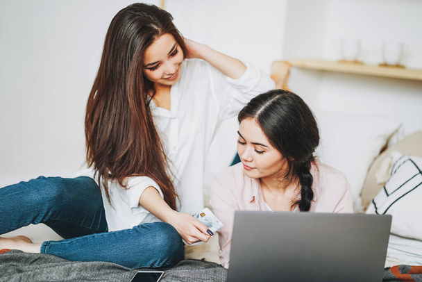 Mladé bezstarostné brunetky dívky přátelé v příležitostné koupit online kreditní kartou na notebooku, nakupování z domova - Fotografie, Obrázek
