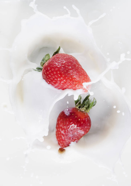 Overseeing falling strawberries in a milk bath - Foto, afbeelding