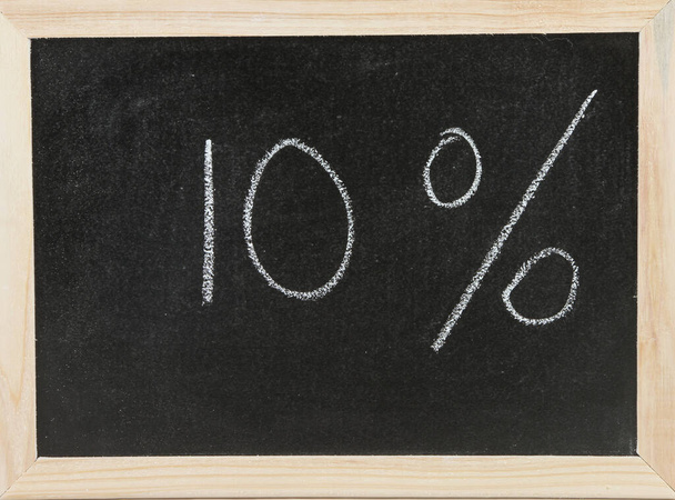 Black chalk board with wooden framed surround and the symbols for Ten percent. - 写真・画像