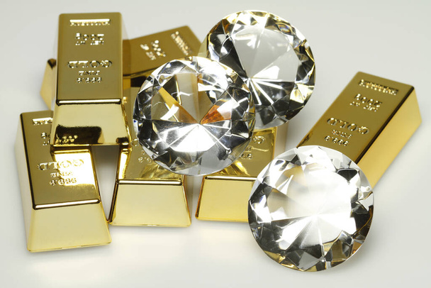gold bars and diamonds are together on the picture. - Foto, Imagen