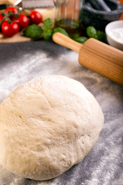 Rolling pizza dough with wooden roller - Photo, Image
