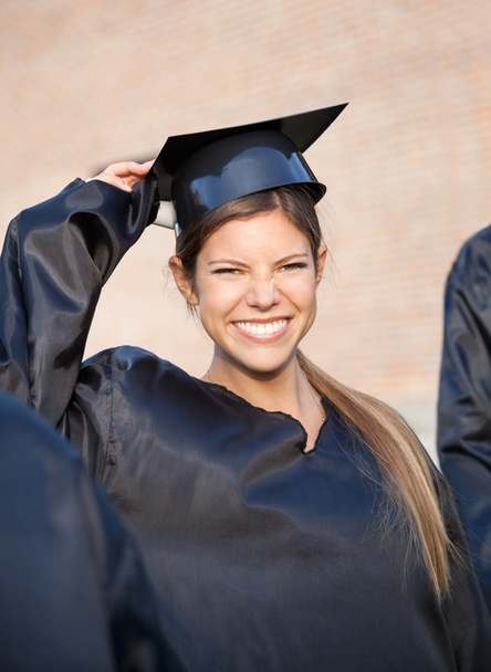 Woman In Graduation Gown Holding Mortar Board On Campus - Foto, imagen