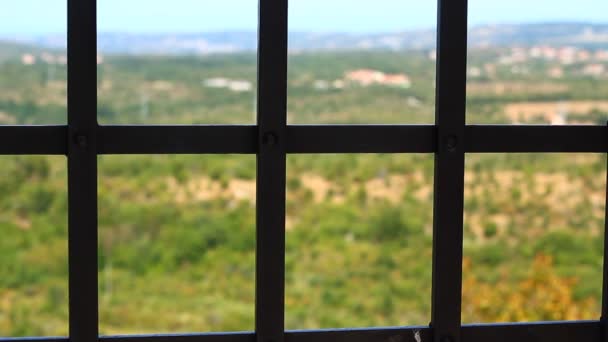 Παρατηρώντας την ελευθερία, τη φύση, τα χωριά, τη θερινή ημέρα μέσω της φυλακής (φυλακή-όπως) παράθυρο, μέσα από ισχυρό σφυρήλατο σίδερο (φυλακή) σχάρες, παλιό κάστρο - Πλάνα, βίντεο