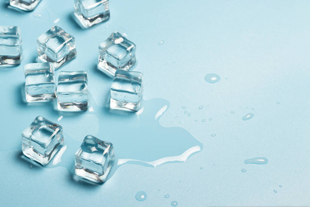 Ice cubes with water on a blue background. Ice concept for drinks. Banner. Flat lay, top view - Photo, Image