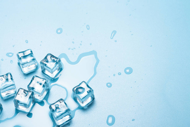 Cubes de glace avec de l'eau sur fond bleu. Concept de glace pour les boissons. Bannière. Couché plat, vue du dessus
 - Photo, image