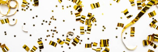 Arany konfetti fehér háttérrel. A koncepció az ünnep, party, születésnap, dekoráció. Banner Lapos fektetés, felülnézet - Fotó, kép