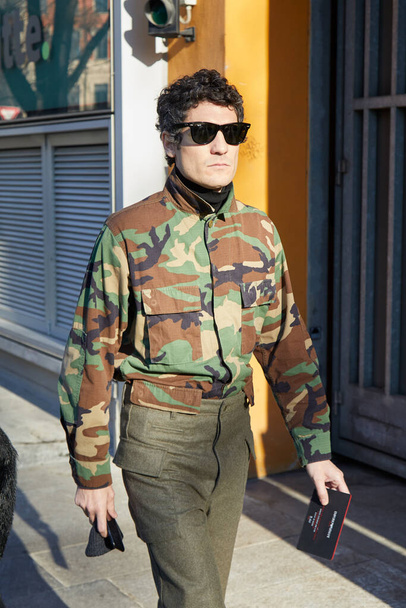 Man with camouflage shirt and olive green trousers before Emporio Armani fashion show, Milan Fashion Week street style  - Фото, изображение