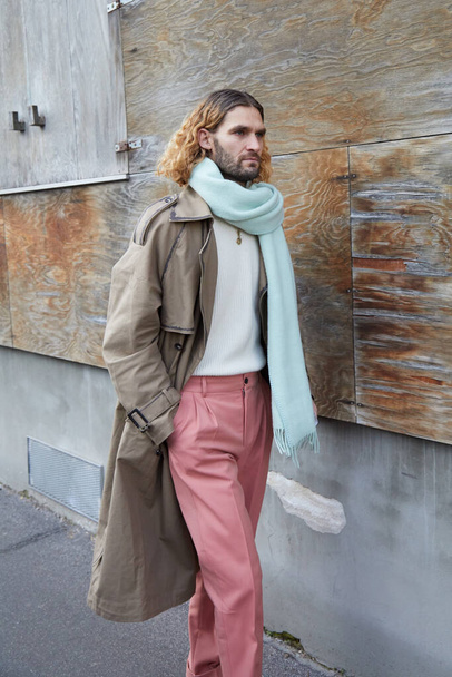 Man with antique pink trousers and beige coat before Marni fashion show, Milan Fashion Week street style  - Foto, imagen