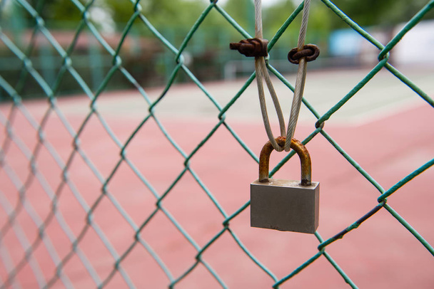 Закрыть ржавый замок на проволочном заборе
 - Фото, изображение