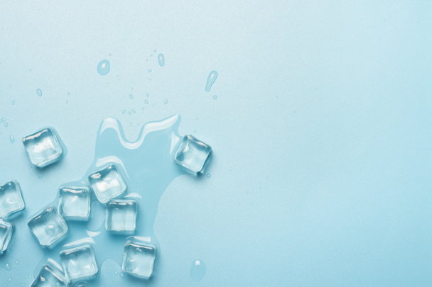 Cubi di ghiaccio con acqua su sfondo blu. Concetto di ghiaccio per bevande. Bandiera. Posa piatta, vista dall'alto
 - Foto, immagini