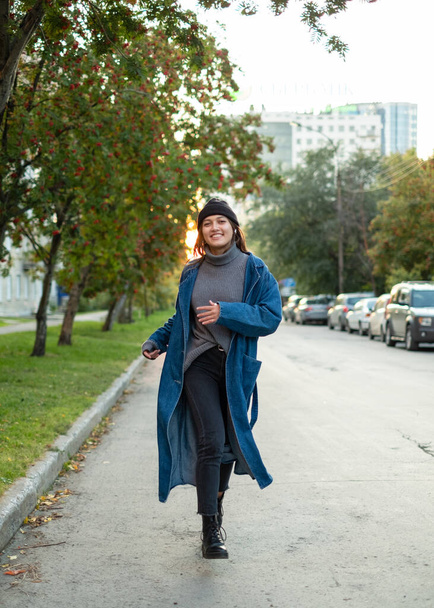 girl in stylish hipster outfit running and having fun. Exiting emotions. Autumn mood. Wearing gray sweater. Fashion. - Foto, imagen