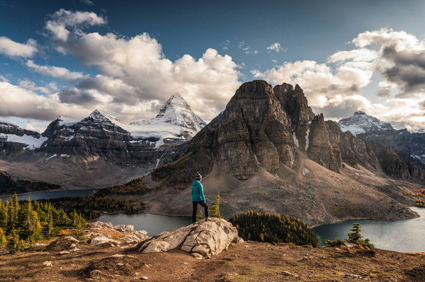 Women traveler standing on cliff with Mount Assiniboine on Nible - Photo, image