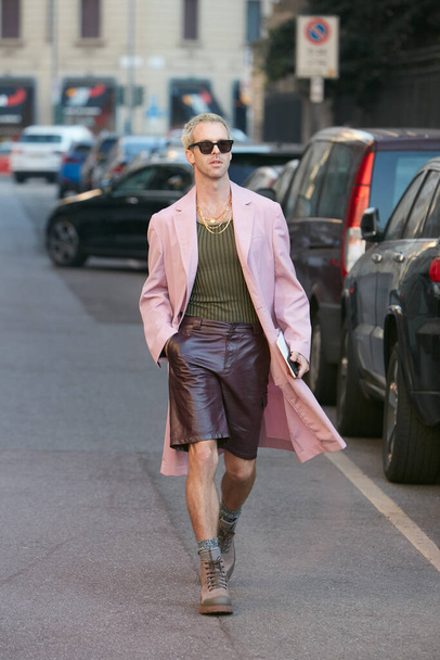 Man with pink coat and brown leather trousers before Salvatore Ferragamo fashion show, Milan Fashion Week street style  - Φωτογραφία, εικόνα