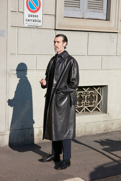 Man with black leather coat before Salvatore Ferragamo fashion show, Milan Fashion Week street style  - 写真・画像