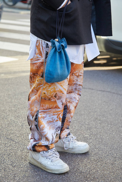 Man with white Nike sneakers and trousers with orange design before Salvatore Ferragamo fashion show, Milan Fashion Week street style  - Foto, Imagem