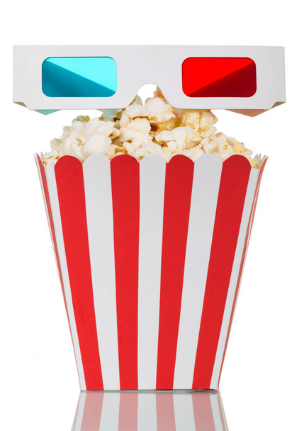 Striped box filled with popcorn and 3D glasses on white. - Zdjęcie, obraz
