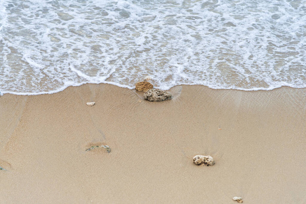 トップビュー海から柔らかい波が湿った砂のビーチの背景に来ています。テキストまたはデザインのコピースペース付き - 写真・画像