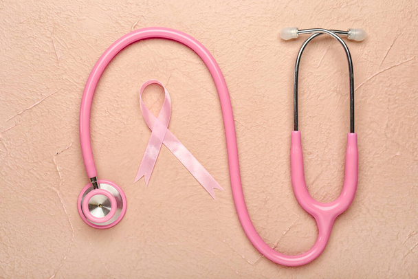 Ruban rose avec stéthoscope sur fond de couleur. Concept de sensibilisation au cancer du sein
 - Photo, image