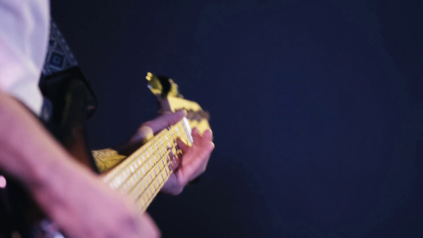 ostříhaný pohled na tetovaného muže hrajícího na elektrickou kytaru izolovanou na modré - Záběry, video