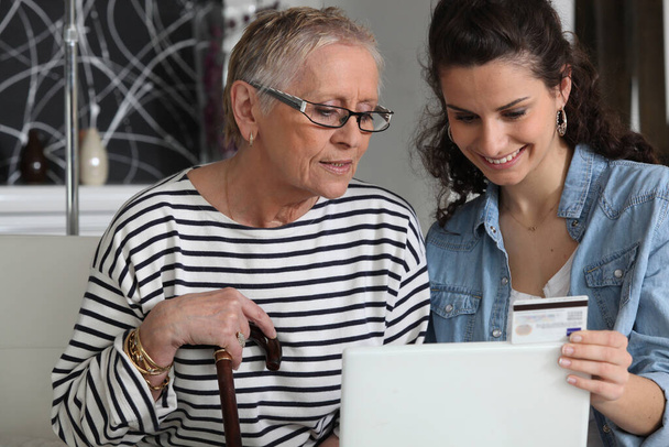 grandma and home helper with laptop - 写真・画像