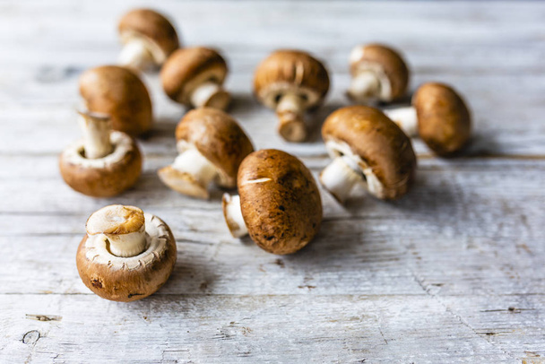 Fresh brown mushrooms in a wooden background. - Photo, Image