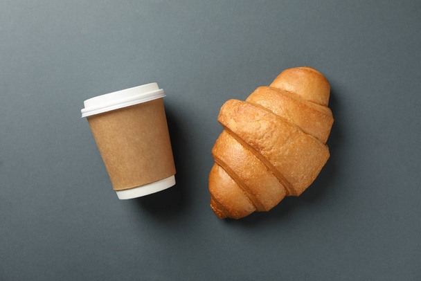 Croissant e xícara de papel de café no fundo escuro, espaço para
  - Foto, Imagem